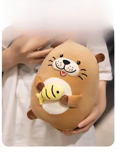 Detail of cute otter plush toy holding a yellow fish with soft brown fur texture