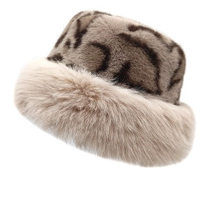 Detail of plush faux fur leopard bucket hat with thick beige fur brim for winter