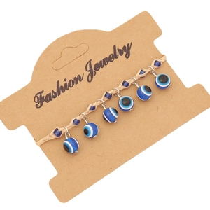 Bohemian woven rope evil eye bracelet with blue beads on jewelry display card