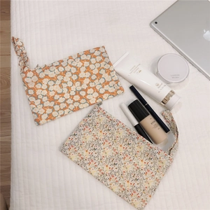 Detailed flat lay of floral cotton cosmetic bags with convenient wristlet hand straps