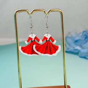 Close-up of red acrylic Christmas dress earrings on a gold stand with sharp details