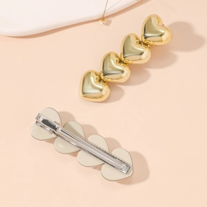 Minimalist gold alloy hair clip with row of 3D hearts and metal duckbill clip