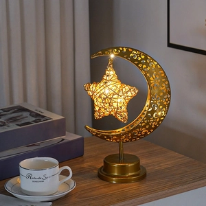 Détail de lampe LED lune dorée et étoile en rotin avec éclairage d'ambiance chaud