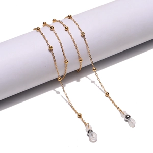 Golden metal beaded chain for glasses or masks featuring silicone loops on a white stand