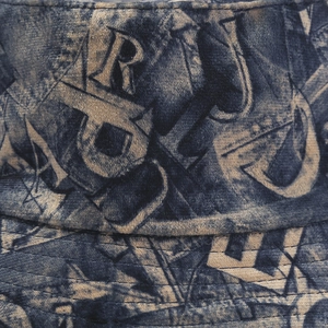 Détail macro du tissu denim vintage avec imprimé graffiti de lettres artistiques