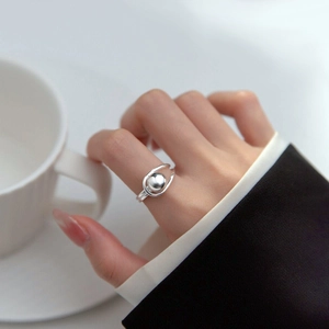 Minimalist double layer silver ring with round bead worn on finger for an elegant style