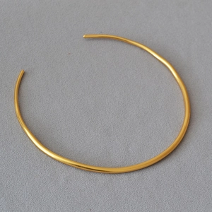 Detail view of gold-plated minimalist brass choker necklace with polished open-loop design