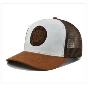 Detail of suede visor and mesh panels on a two-tone trucker hat with round patch