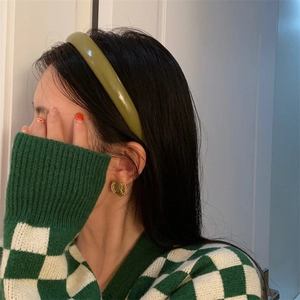 Olive green headband with vintage gold coin earrings worn by a model in a knit sweater