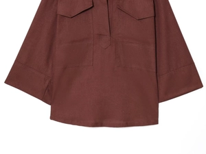 Detail view of the deep reddish-brown texture with symmetrical chest flap pockets