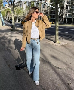 Street style view of khaki faux suede cropped jacket with metal buttons and blue jeans