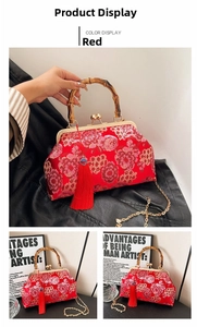 Detail of red satin handbag with floral embroidery, bamboo handle and red tassel ornament