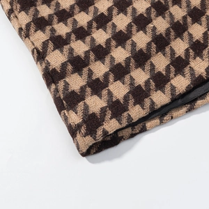 Detailed macro view of coffee and beige houndstooth woven fabric with black satin lining