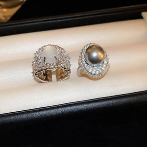 Detail shot of pearl and oval gemstone rings with diamond halo in a luxury jewelry box