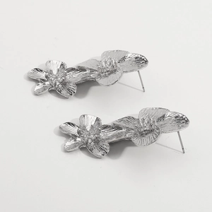 Detailed view of silver flower earrings with textured metallic finish and double blossom design