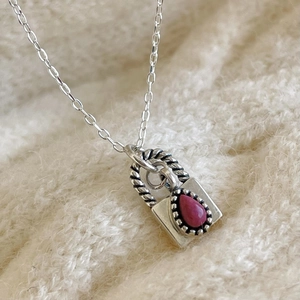 925 silver necklace with pink gemstone lock pendant on cozy white knit sweater