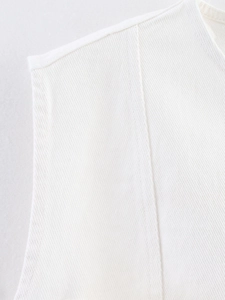 Close-up detail of white sleeveless denim top showing twill fabric texture and stitching