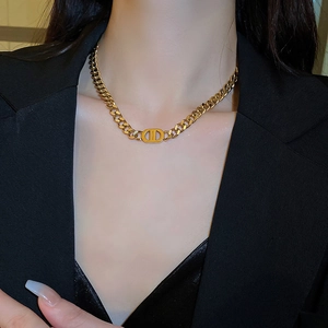 Vintage gold stainless steel Cuban chain necklace with iconic cutout logo pendant