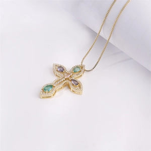 Gold cross necklace with colorful zircon gemstones and clear diamonds on white background