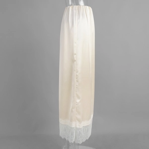 Detail of satin skirt with eyelash lace hem showing smooth texture and floral pattern