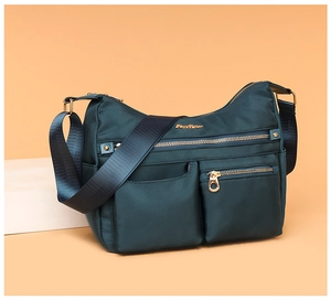 Close-up of waterproof nylon shoulder bag with golden zippers and multiple pockets
