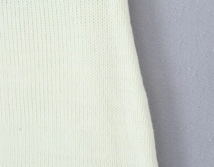 Detailed macro view of the cream white knitted fabric texture and fine stitch pattern