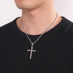 Men's silver twisted cross pendant necklace in stainless steel on black t-shirt