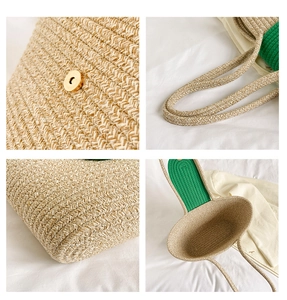 Detail view of woven straw tote bag featuring green fabric trim and magnetic buckle