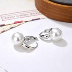 Elegant silver hoop earrings with large white pearls on a minimalist white background