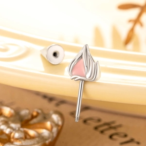 Silver cat ear cartilage stud earring with pink enamel and screw back on a ceramic plate