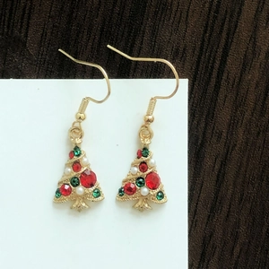 Close-up of Christmas tree earrings with colorful rhinestones and white pearls
