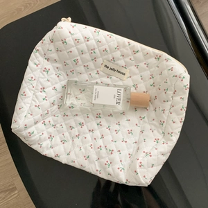 Quilted floral makeup bag with cherry pattern and secure metal zipper closure