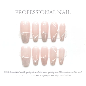 Close-up of nude pink coffin press-on nails with silver glitter, 3D pearls, and white lines