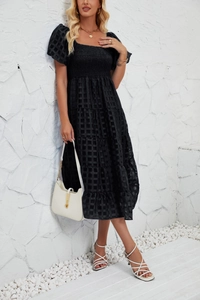 Detail of black tiered midi dress with puffed sleeves and textured smocked grid fabric
