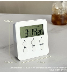 Detail of white mini digital timer showing LCD screen and size metrics on marble surface