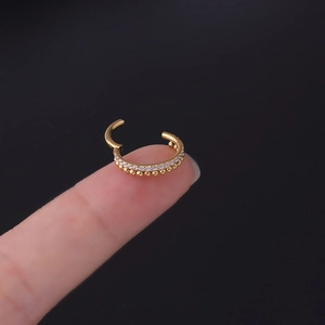 Macro view of gold stainless steel hinged ring with double rows of beads and crystals
