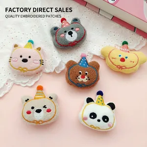 Close-up of cute cartoon plush animal brooches featuring cats and bears with party hats