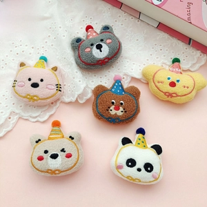 Close-up of cute cartoon plush animal brooches featuring cats and bears with party hats