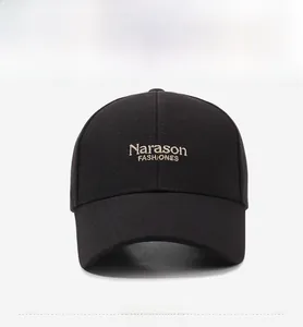 Close-up of champagne gold Narason embroidery on a black twill cotton baseball cap