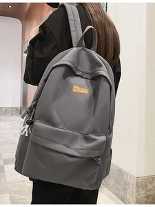 Minimalist large capacity dark grey backpack for students and adults shown on a model