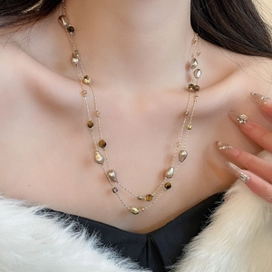 Detail of 18k gold plated double layer necklace with tiger eye and pearl beads
