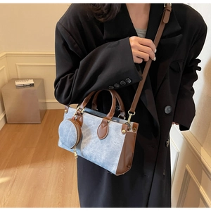 Detail of blue denim and brown leather tote bag with a matching round mini coin purse