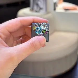 Elegant geometric open ring featuring a cluster of colorful zircon gemstones on gold band