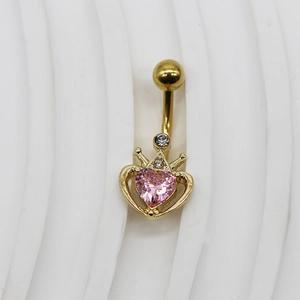 Détail d'un piercing de nombril en cœur avec couronne et pierre rose en fini doré