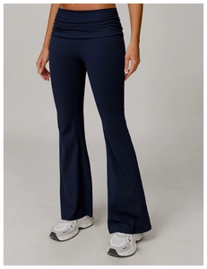 Detail of high-waisted navy flare yoga pants featuring stylish waist pleats and elastic fabric