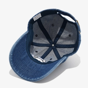 Detail of denim baseball cap interior showing 100% cotton label and panda embroidery