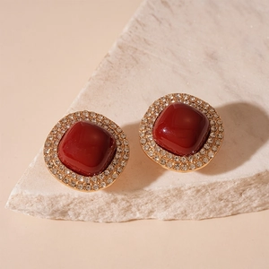 Détails de boucles d'oreilles carrées avec pierre rouge et halo de cristaux dorés