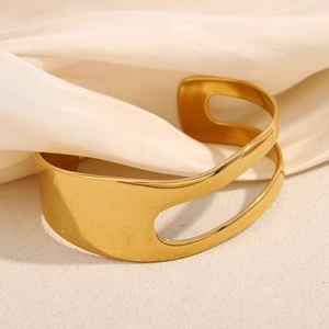 Detail of 18K gold plated asymmetric double-layer bangle on beige satin silk background