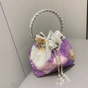 Dettaglio borsa a secchiello da sera con strass luccicanti, manico argento e nappa