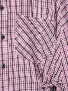 Détail d'une chemise à carreaux rose avec poche poitrine, boutons et lien à la taille